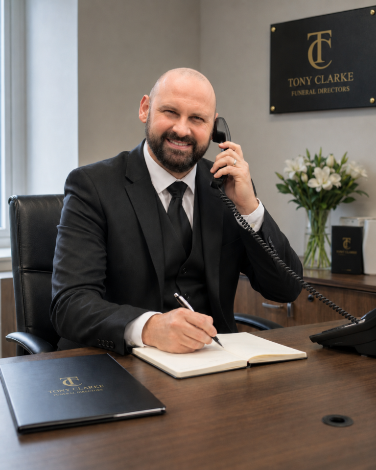 Marek Clarke answering a phone call at a funeral director office desk in Sunderland. death at home Sunderland
