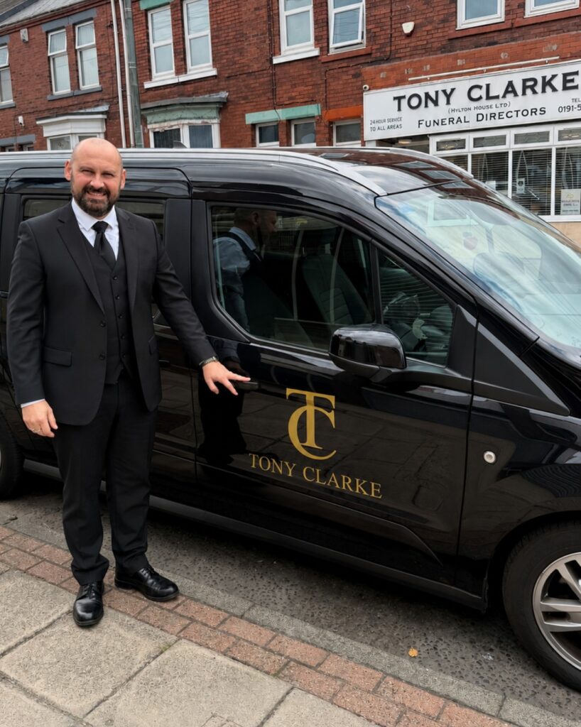 Marek Clarke standing beside a Tony Clarke Funeral Directors vehicle outside the Sunderland funeral home. death at home Sunderland